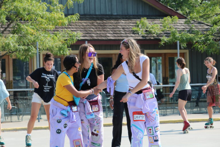 Faculty representatives smiling and laughing while rollerblading.