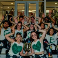 Commerce Representatives posing on the stairs holding the Airbands trophy.