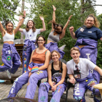 Representatives sitting and jumping while smiling at the camera.