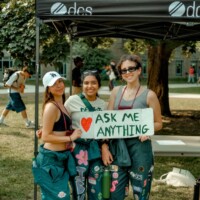 A group of Faculty Representatives smiling and holding a sign that says 'ASK ME ANYTHING'.