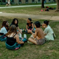 A group of Faculty representatives and First-year students sitting in a circle, talking.