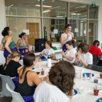 Representatives and First-year Students painting plant pots.
