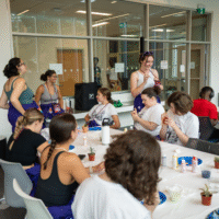 Representatives and First-year Students painting plant pots.