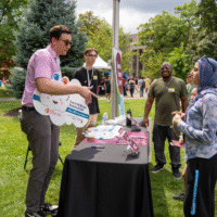 First-year students talking to a representative at a booth.