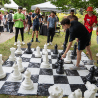 First-year students playing a larger version of chess on the grass.