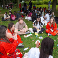 A group of first-year students and representatives sitting in a circle eating.