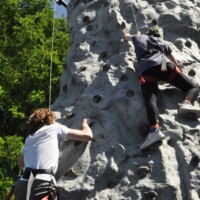 First-year students climbing a rock wall outside.