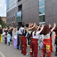 Faculty representatives facing each other, making a tunnel for incoming cars during move-in.