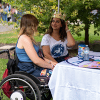 Faculty representatives sitting at a table, one is wearing a crown.