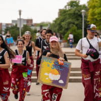 Representatives running holding signs that say 'HERE COMES the SUN'.