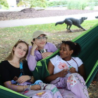 Faculty representatives smiling on a hammock.