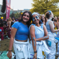 Faculty representatives smiling at camera wearing blue paint which says 'BLEED BLUE' on arms.