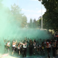 Faculty reps and first-year students being covered in green dust.