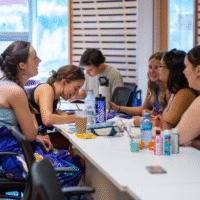 A group of representatives painting at a table.