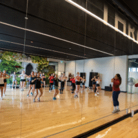 First-year student following an instructor teaching a fitness class.